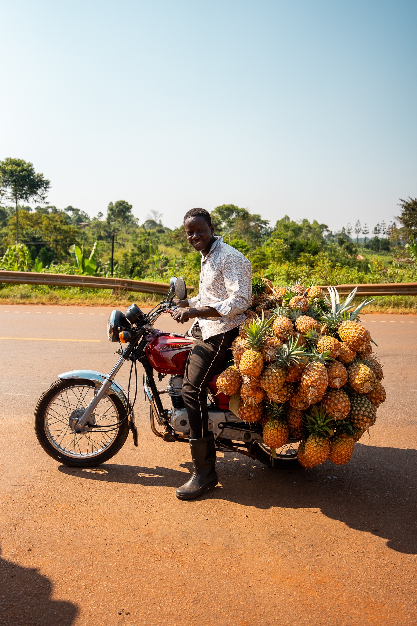 local portant des ananas sur une moto ouganda
